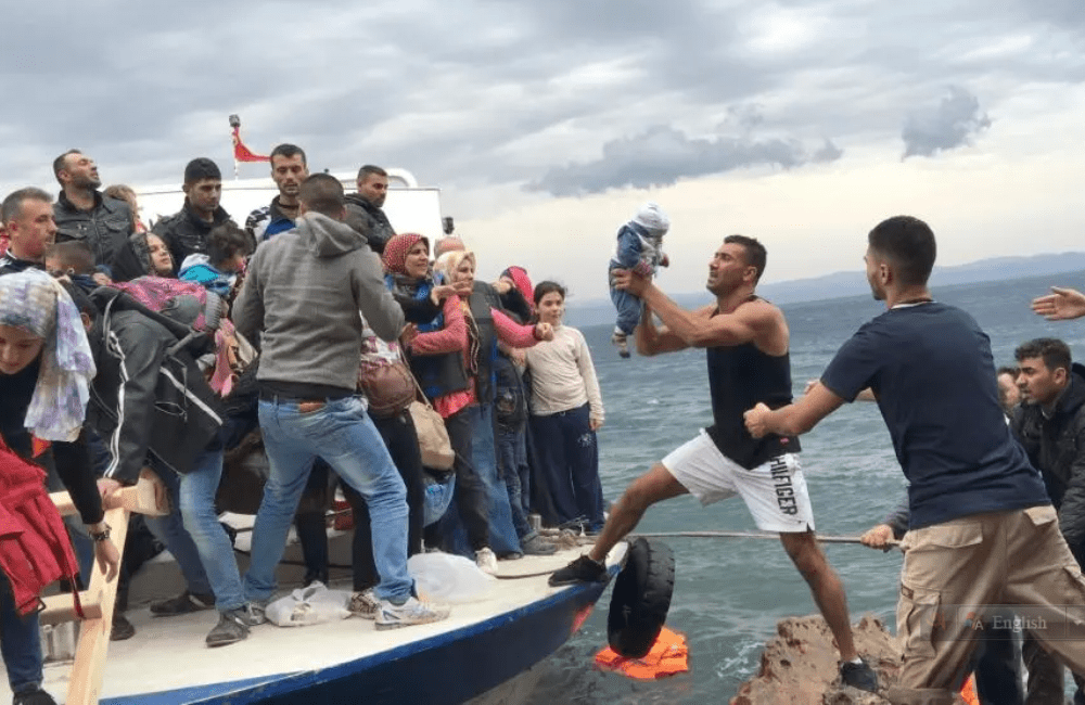 Asylum seekers and migrants descend from a large fishing vessel used to transport them from Turkey to the Greek island of Lesbos. October 11, 2015. © 2015 Zalmaï for Human Rights Watch